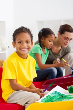 Happy Indian preschool boy in classroom clipart