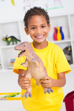 Preschool boy playing with dinosaur clipart