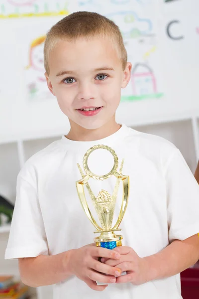 Menino pré-escolar segurando um troféu — Fotografia de Stock