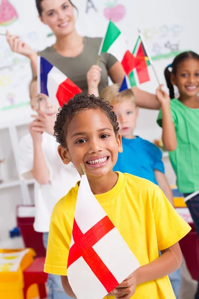 就学前の子供たちと教師のグループで教室に旗を掲げて — ストック写真