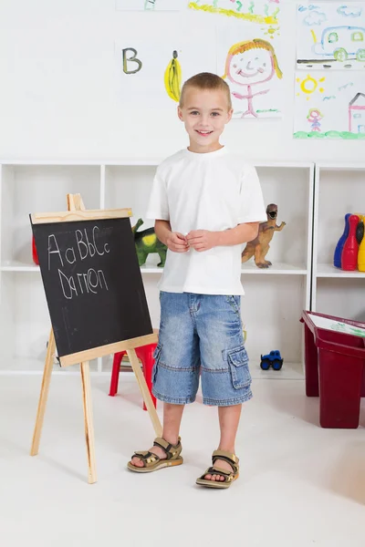 Předškolní chlapce před tabulí — Stock fotografie