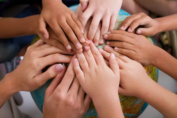 Diversity kids hands together on globe — Stock Photo, Image