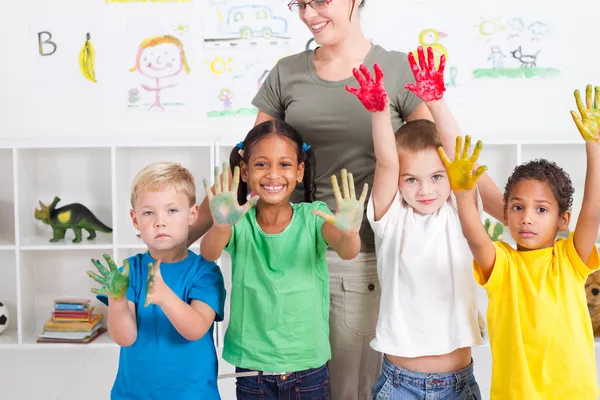 Grupy dzieci w wieku przedszkolnym z ręki farby w klasie — Zdjęcie stockowe