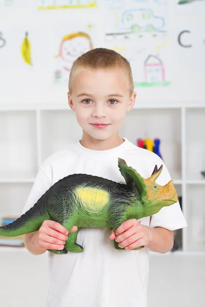 Προσχολικής ηλικίας παιδί παίζει με δεινόσαυρο — Φωτογραφία Αρχείου