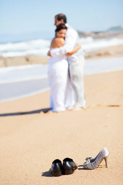 Невеста и жених обнимаются на пляже — стоковое фото