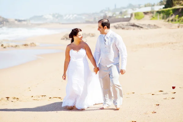 新郎和新娘沙滩上散步 — 图库照片