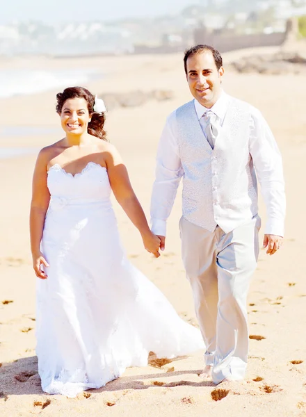 Жених и невеста гуляют по пляжу — стоковое фото