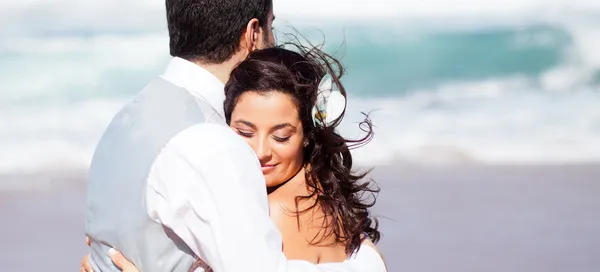 Novia y novio abrazándose en la playa — Foto de Stock