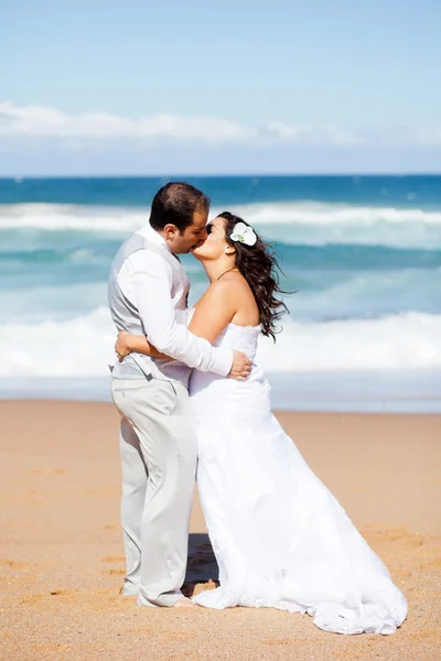 Recién casados pareja besándose en la playa — Foto de Stock
