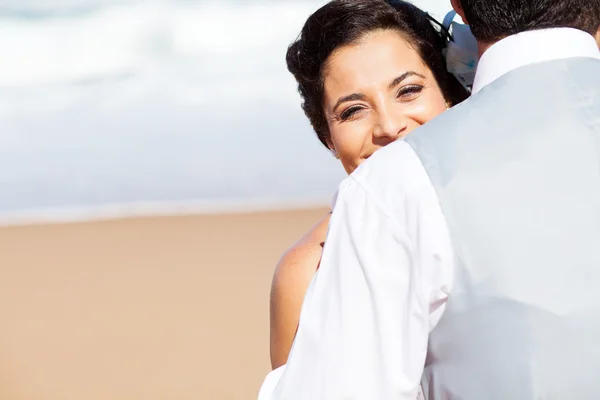 Счастливая женщина обнимает мужа на пляже — стоковое фото