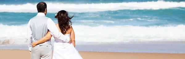 Brudgummen och bruden på stranden — Stockfoto