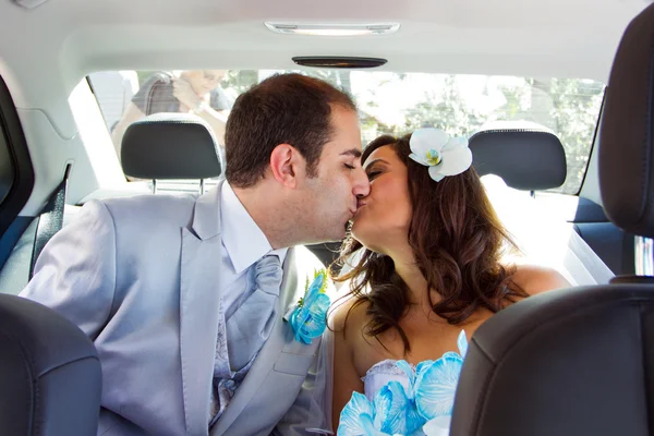 Novomanželský pár líbat navzájem v limuzíně — Stock fotografie
