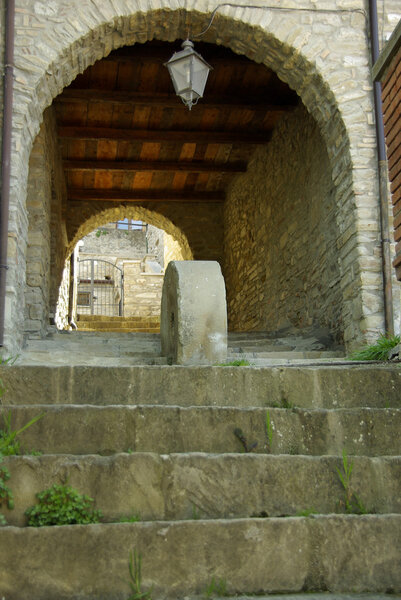 Stone steps leading to an empty undercover arched walkway, architectural detail