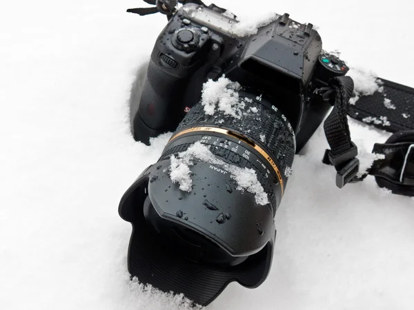 相机和镜头在雪中 免版税图库图片