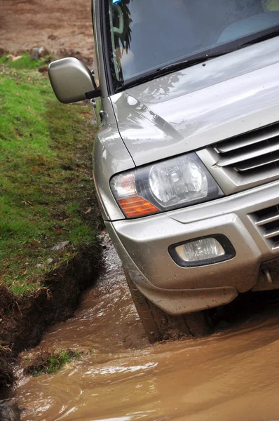 SUV overcomes a pit of mud — Stock Photo, Image