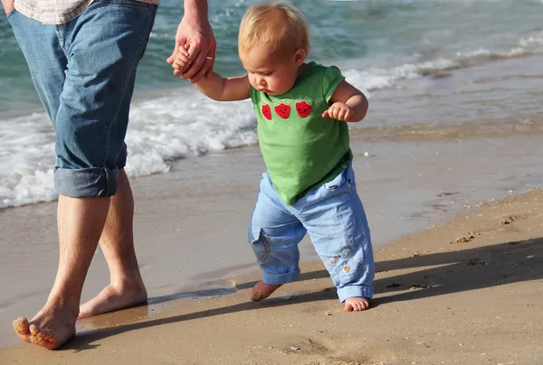 Barn tar sina första steg. far och dotter till havet. — Stockfoto