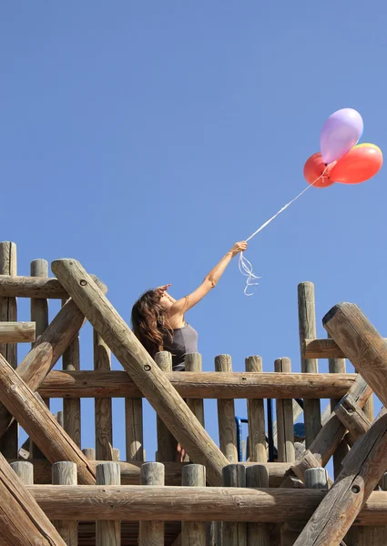 Молода жінка з різнокольоровими кульками в полі — стокове фото