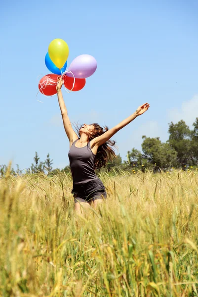 Young woman with colorful balloons. Photo in old image style. — Stock Photo, Image