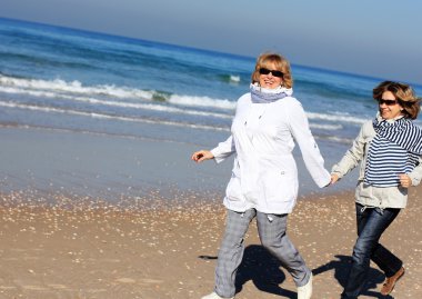 Mother and daughter on a winter beach clipart