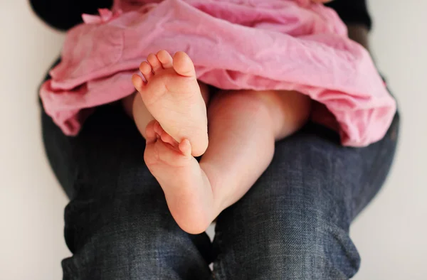 Little girl in pink dress sitting on her mother's hands — Stock Photo, Image