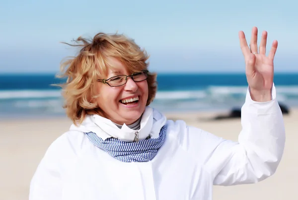 Старшая женщина с вытянутыми руками на Зимнем пляже — стоковое фото