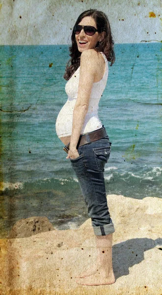 Pregnant woman on the beach. Photo in old image style. — Stock Photo, Image