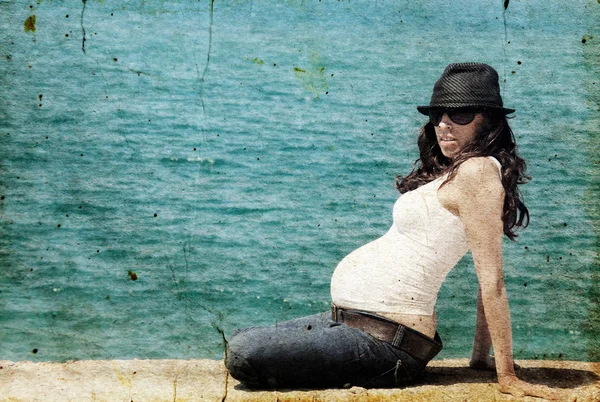 Młoda kobieta w ciąży z zabawka przeciw błękitne morze — Zdjęcie stockowe