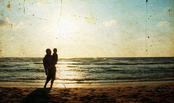 Vader en zoon op zee kijken naar de sunse — Stockfoto