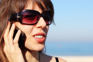 Cep telefonuyla konuşan mutlu genç bayan.