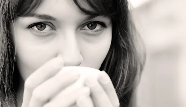 Młoda dziewczyna z filiżanką kawy. skupić się na oczy. — Zdjęcie stockowe