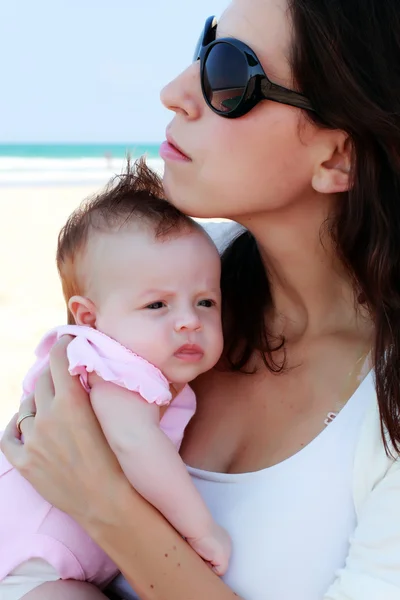 Moeder met haar baby op het strand — Stockfoto