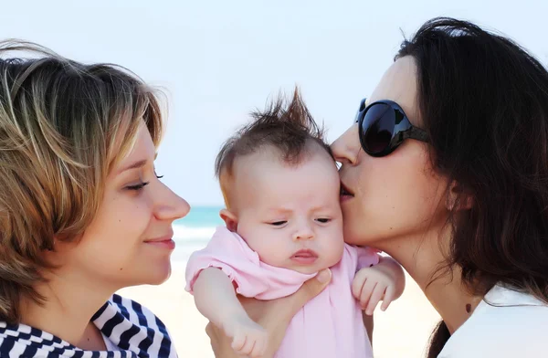 ビーチで赤ちゃんを持つ 2 つの美しい女の子 — ストック写真