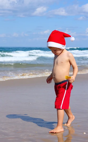 Garçon de 4 ans dans le chapeau du Père Noël sur la plage — Photo
