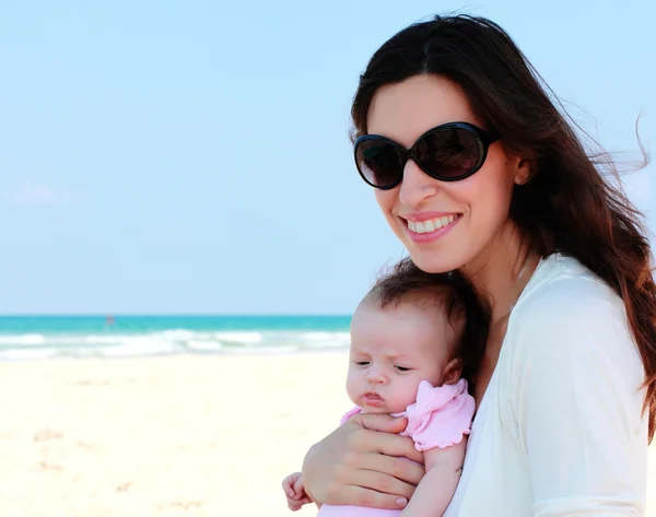 Moeder met haar baby op het strand — Stockfoto