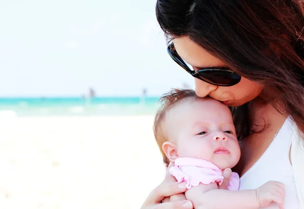 Mor med sitt barn på stranden — Stockfoto