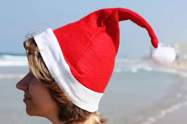 Noël en mer. Fille dans Santa chapeau sur la plage . — Photo