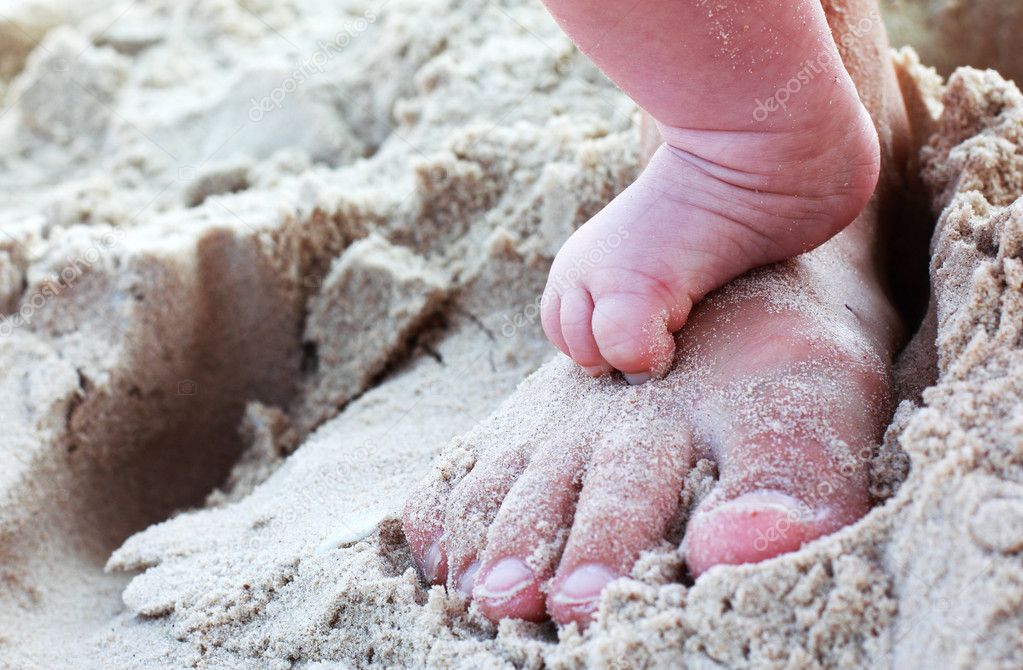 Mom's and baby's feet on the beach