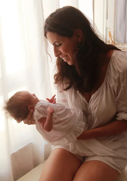 30-jährige schöne Mutter hält ihre neugeborene Tochter — Stockfoto