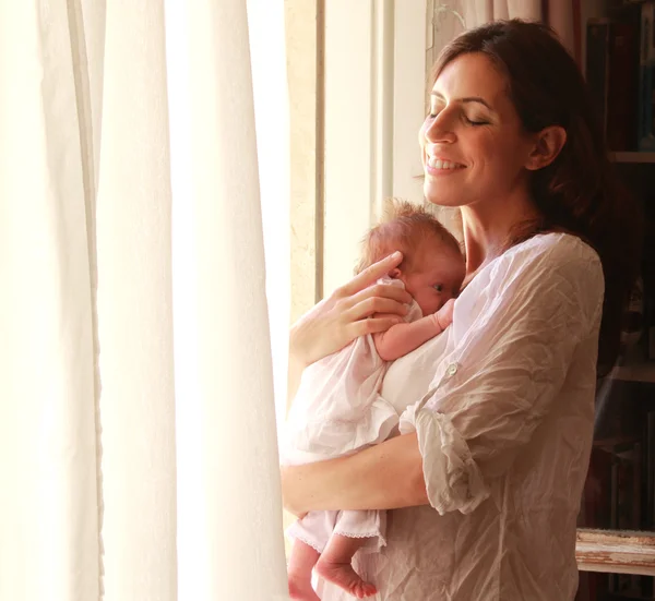 30-летняя красивая мама держит свою новорожденную дочь — стоковое фото