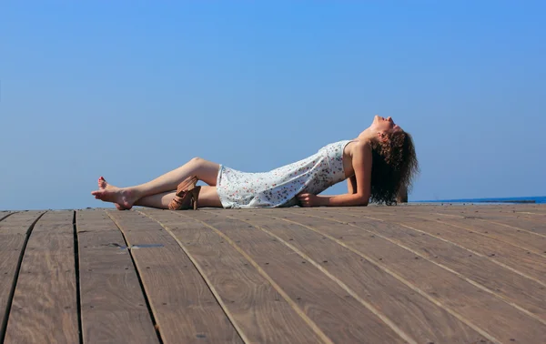 Молодая женщина лежит и смотрит на небо — стоковое фото