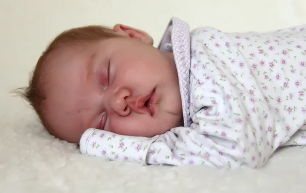 Monthly baby sleeping on a white blanket — Stock Photo, Image