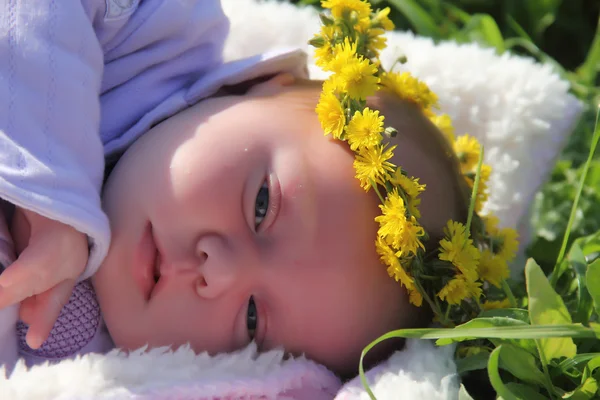 Month-old girl lying on white blanket next to the red poppies — Stock Photo, Image