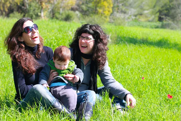 봄 배경에서 아기와 함께 두 명의 아름 다운 여자 — 스톡 사진