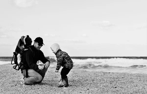 Táta s malým dítětem chodit na zimní beach. — Stock fotografie