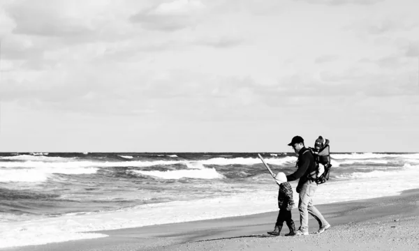 Papá con un niño pequeño caminando en una playa de invierno . —  Fotos de Stock
