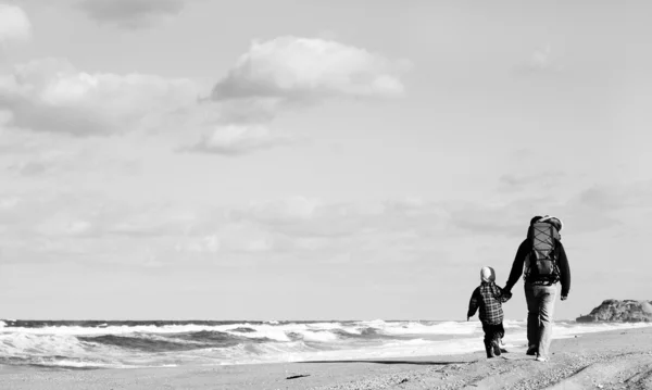 Pappa med ett litet barn gå på en vinter strand. — Stockfoto