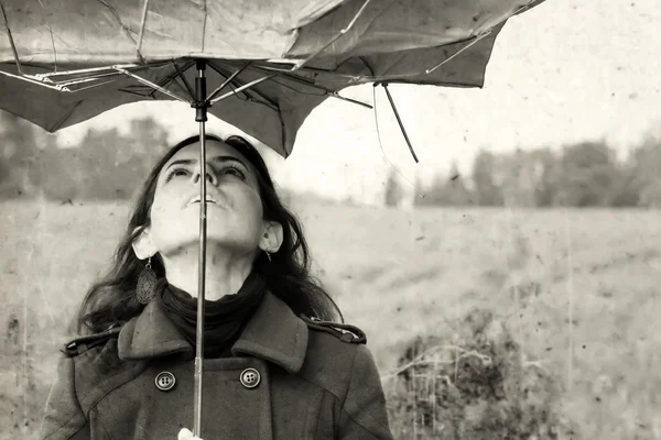 Girl with umbrella in the field. Photo in old color image style. — Stock Photo, Image