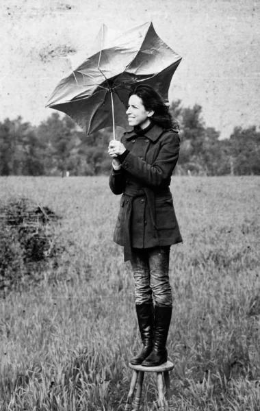 Meisje met paraplu in het veld. foto in oude kleur beeld stijl. — Stockfoto