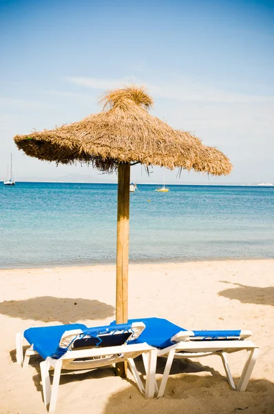 Liegestühle und Sonnenschirme am Meer. Portugiesisch. Wilde Moura. lizenzfreie Stockbilder