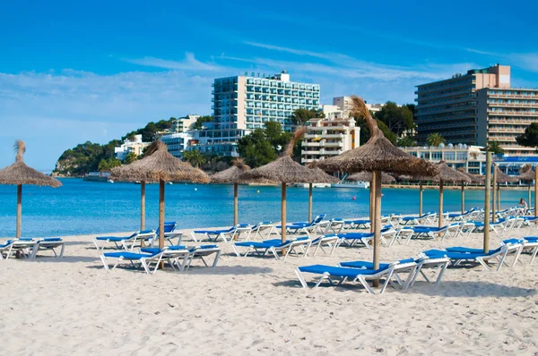 Liegestühle und Sonnenschirme am Strand. Spanien, Palma Mallorca lizenzfreie Stockfotos